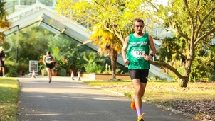 Man running with a MacMillan charity vest on